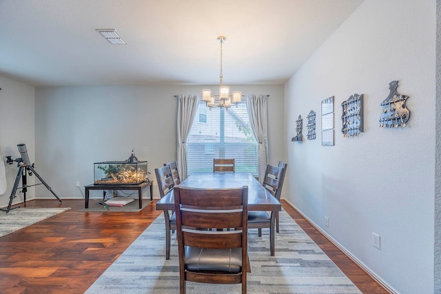 dining room featuring dark hardwood / wood-style flooring and an inviting chandelier