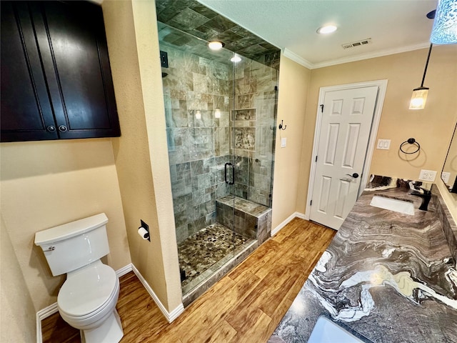 bathroom featuring hardwood / wood-style flooring, vanity, an enclosed shower, toilet, and crown molding