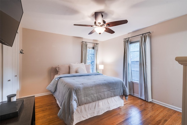 bedroom with dark hardwood / wood-style flooring, multiple windows, and ceiling fan