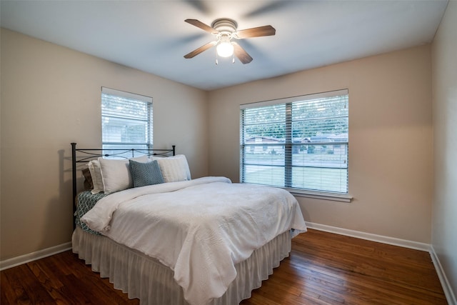 bedroom with ceiling fan, dark hardwood / wood-style flooring, and multiple windows