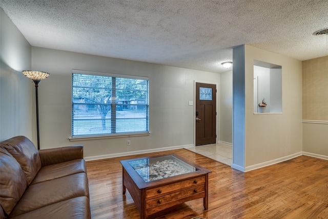 living room featuring a textured ceiling and hardwood / wood-style flooring