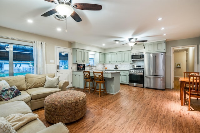 living room featuring ceiling fan and light hardwood / wood-style flooring