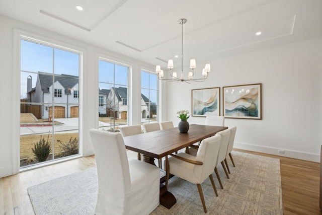 dining space featuring a healthy amount of sunlight, light wood-style flooring, and baseboards