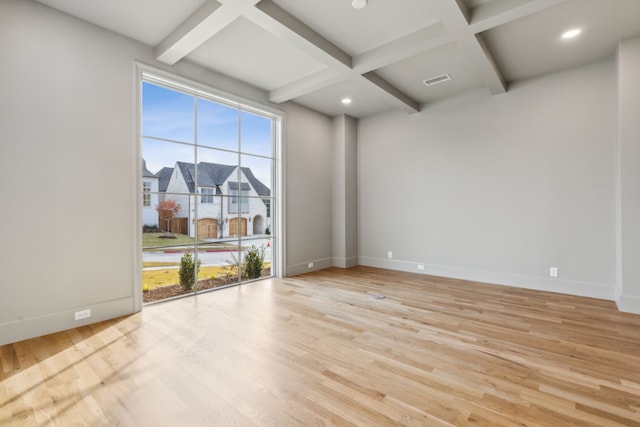 spare room with beam ceiling, light hardwood / wood-style floors, and coffered ceiling