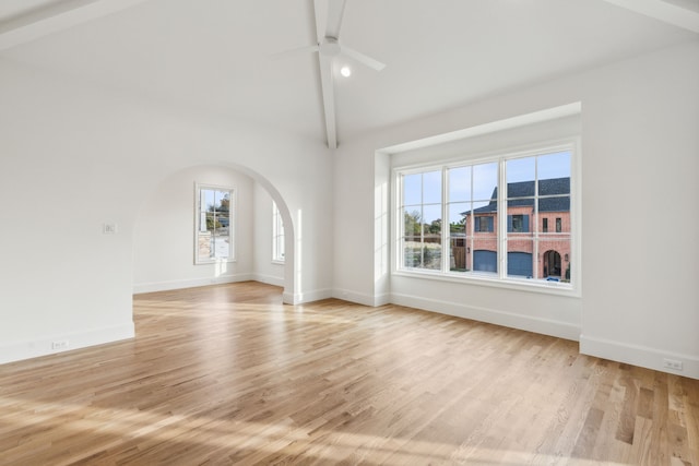 unfurnished living room featuring light wood-type flooring, vaulted ceiling with beams, and ceiling fan