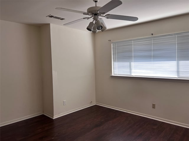 empty room with dark wood-type flooring and ceiling fan