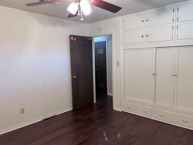 unfurnished bedroom with ceiling fan, dark hardwood / wood-style floors, and a closet