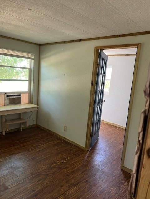 unfurnished room featuring cooling unit, dark hardwood / wood-style flooring, and a textured ceiling