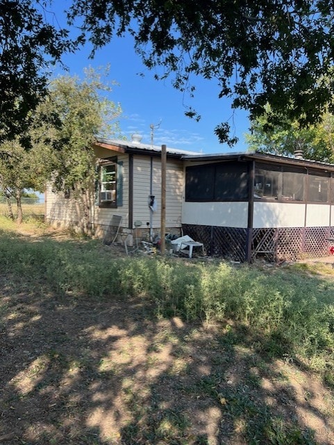 rear view of house featuring a sunroom