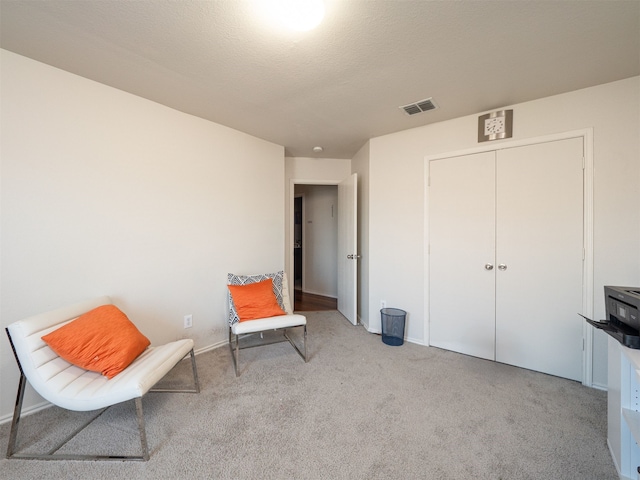 living area with light colored carpet and a textured ceiling