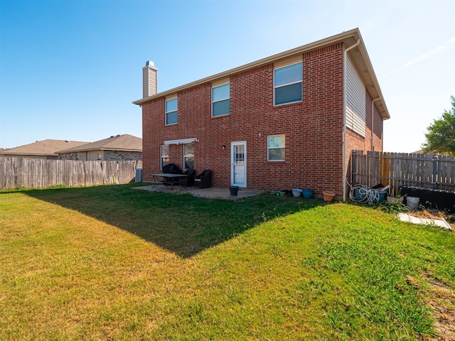 rear view of house with a yard and a patio area