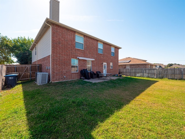 rear view of house with a patio, central AC, and a lawn