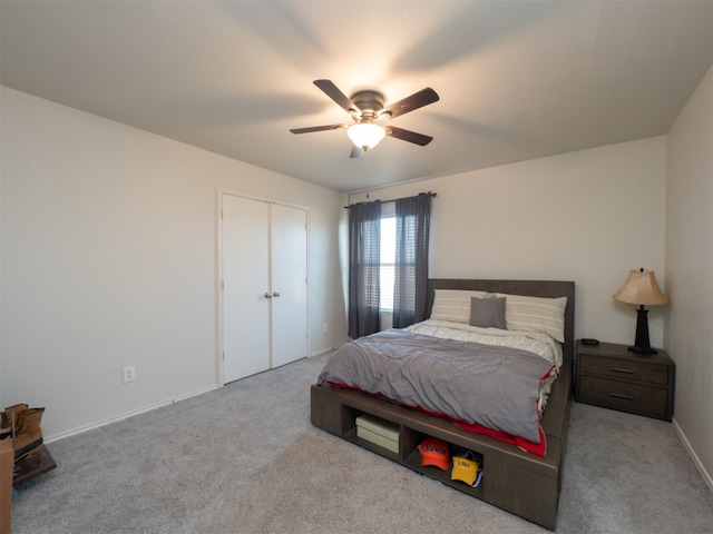 bedroom featuring a closet, light colored carpet, and ceiling fan