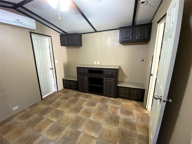 kitchen with lofted ceiling, a textured ceiling, a wall mounted AC, and ceiling fan