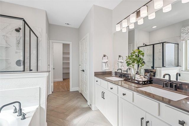 bathroom featuring independent shower and bath, vanity, and parquet floors