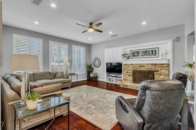 living room featuring ceiling fan, a fireplace, a wealth of natural light, and dark hardwood / wood-style floors