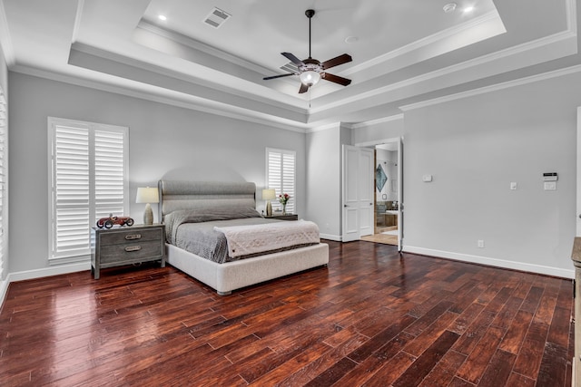 bedroom with crown molding, a tray ceiling, dark wood-type flooring, and ceiling fan