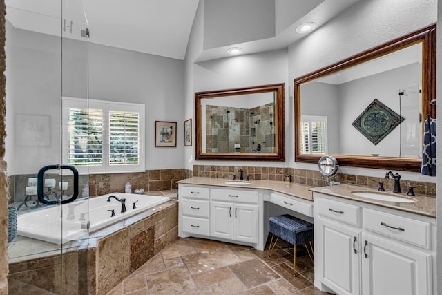 bathroom with vanity, shower with separate bathtub, and high vaulted ceiling