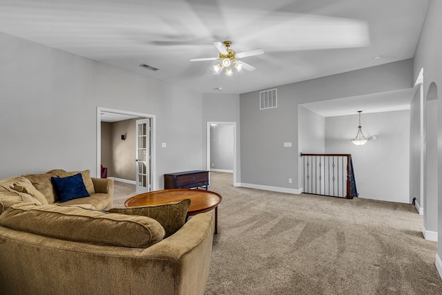 carpeted living room with ceiling fan