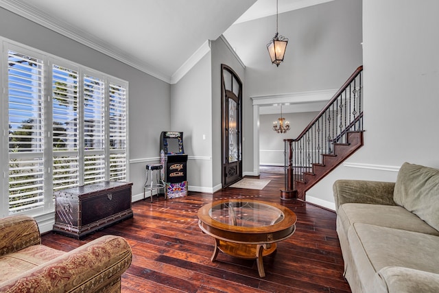 living room with crown molding, hardwood / wood-style flooring, vaulted ceiling, and an inviting chandelier