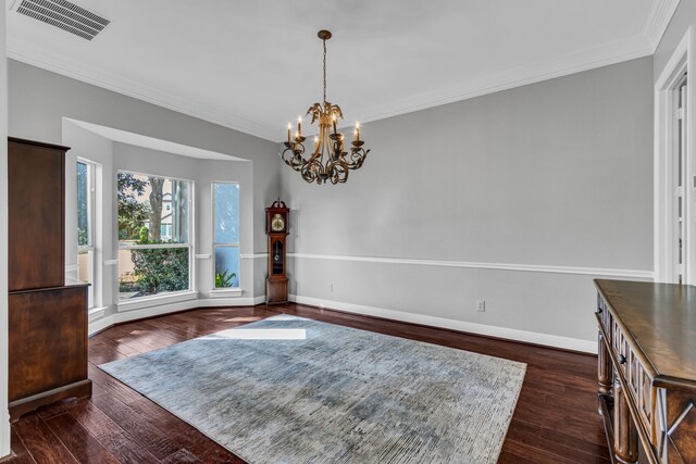 dining room with crown molding, dark hardwood / wood-style flooring, and a chandelier