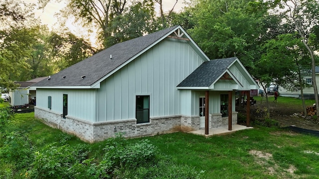 1212 Albertson, Tyler, TX 75702 - rear view of house with a shingled roof, brick siding, and a lawn