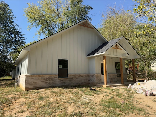 1212 Albertson, Tyler, TX 75702 - view of side of property featuring brick siding, board and batten siding, a patio area, and roof with shingles