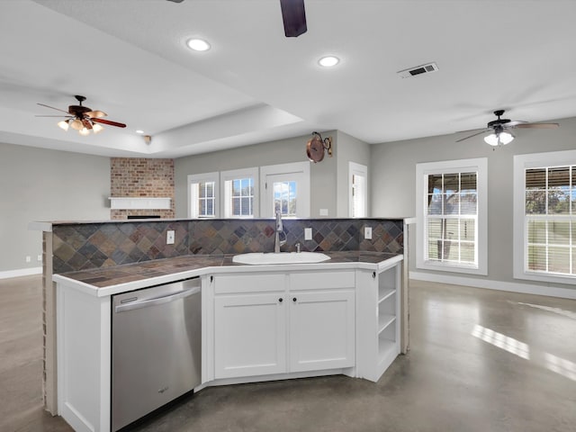 kitchen with backsplash, white cabinets, a brick fireplace, sink, and dishwasher