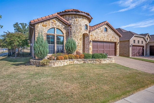 mediterranean / spanish home with a front yard and a garage