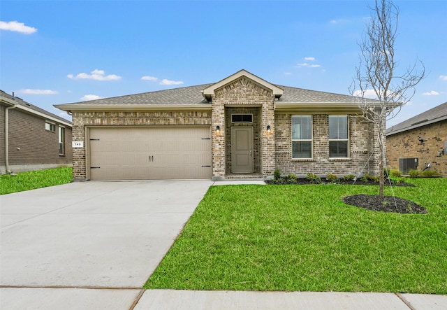 view of front of home with a front yard, central air condition unit, a garage, driveway, and brick siding