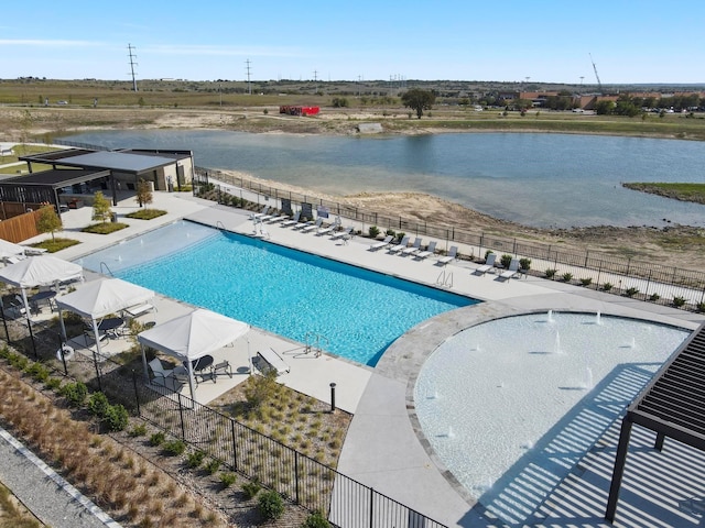 community pool featuring fence, a patio area, and a water view