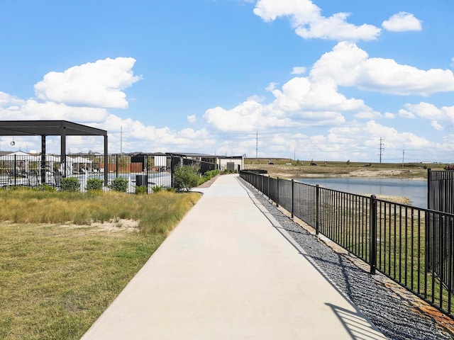 view of community with a water view and fence