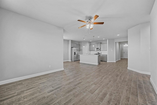unfurnished living room with recessed lighting, ceiling fan, baseboards, and light wood-style floors