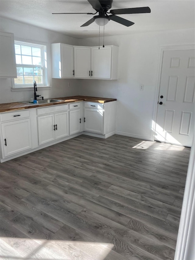 kitchen with wood counters, sink, white cabinets, and dark hardwood / wood-style floors