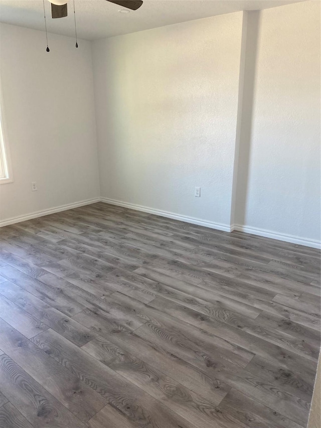 empty room with dark hardwood / wood-style floors and ceiling fan