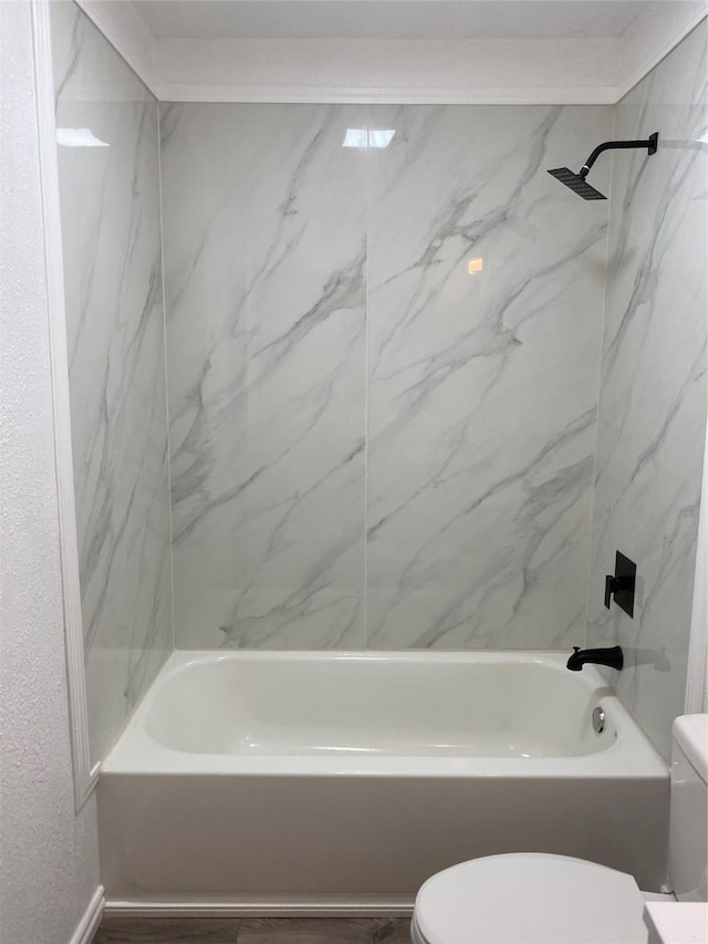 bathroom with tiled shower / bath, toilet, and hardwood / wood-style floors