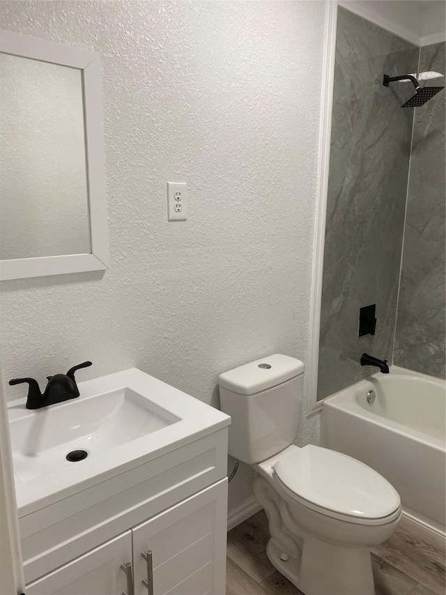 full bathroom with tiled shower / bath, vanity, toilet, and wood-type flooring