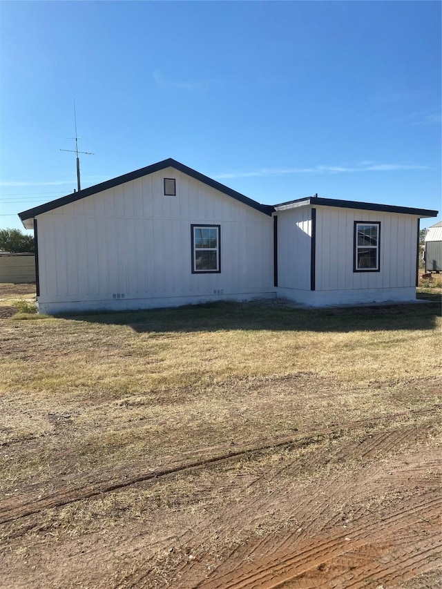 rear view of house featuring a yard