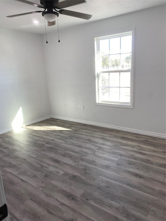 unfurnished room with dark wood-type flooring and ceiling fan