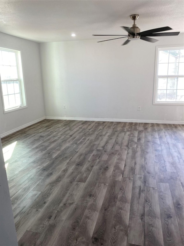 spare room with dark hardwood / wood-style flooring and ceiling fan