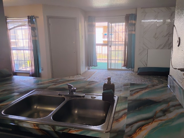 kitchen featuring plenty of natural light, a textured ceiling, and sink