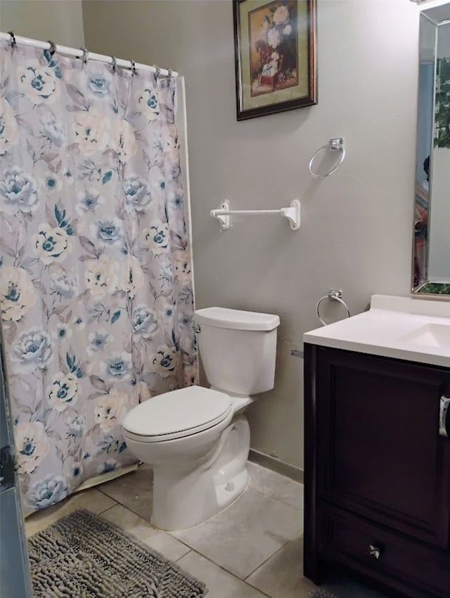 bathroom with tile patterned floors, vanity, curtained shower, and toilet