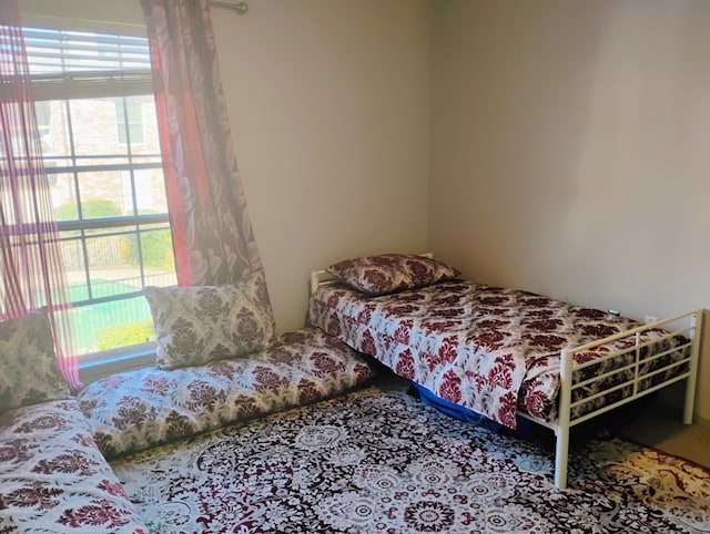 carpeted bedroom featuring multiple windows