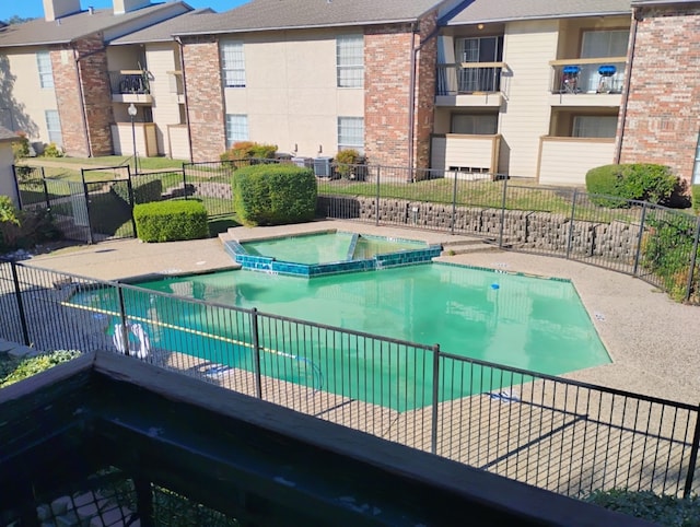 view of swimming pool with a hot tub