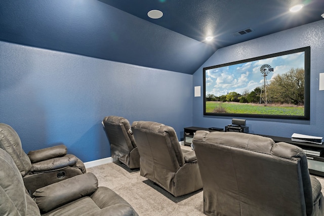 carpeted home theater with vaulted ceiling