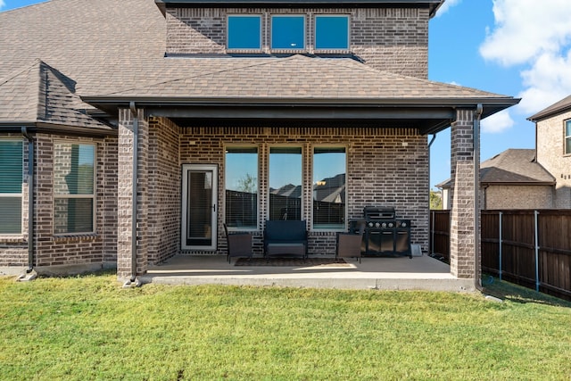 back of house featuring a patio area and a lawn