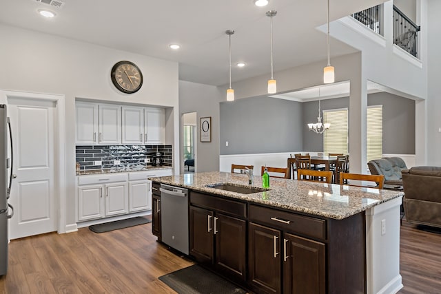 kitchen with sink, dark hardwood / wood-style flooring, stainless steel appliances, pendant lighting, and white cabinets