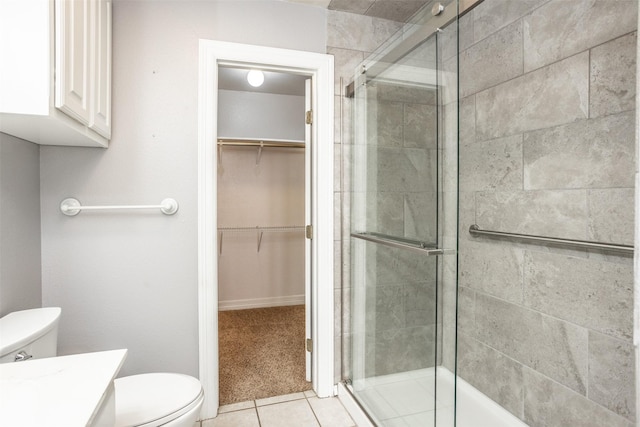 bathroom featuring tile patterned floors, toilet, a shower with door, and vanity