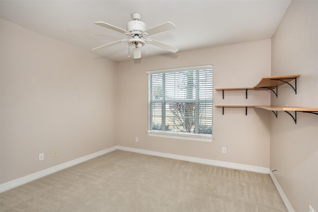 carpeted spare room featuring ceiling fan