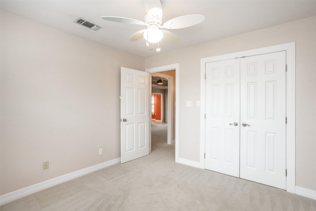 unfurnished bedroom with light carpet, a closet, and ceiling fan